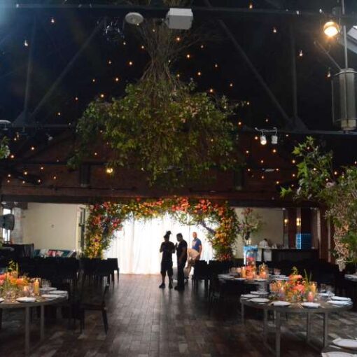String Lights hanging overhead in parallel lines and swoop upward toward the peek of the center ceiling for a wedding at 26 Bridge.
