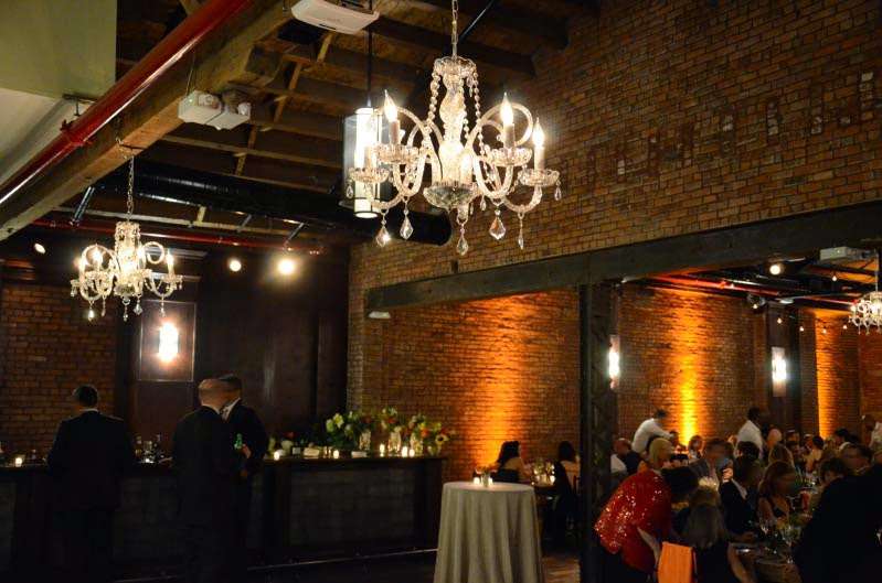 Two chandeliers in the bar area at the rear of the room. 10 amber Up-Lights along the perimeter wall.