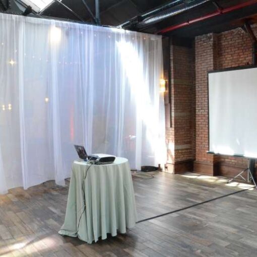 A projector and tripod-base screen for a video montage during a wedding at 26 Bridge.