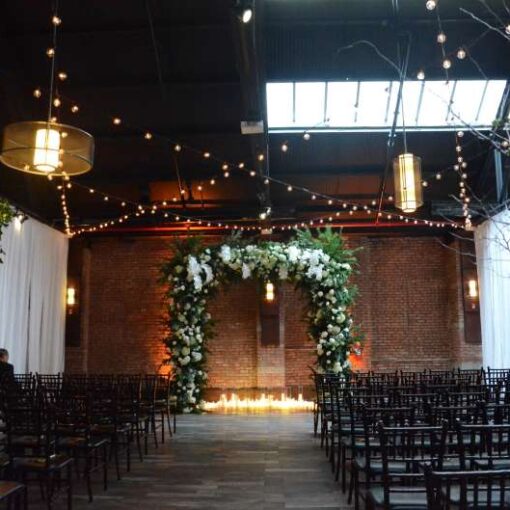 String Lights with Round G50 Bulbs hanging in a five-pointed star/ Pentagram shaped pattern at 26 Bride. Also,  Amber Up-Lights along perimeter wall of main room at 26 Bridge.