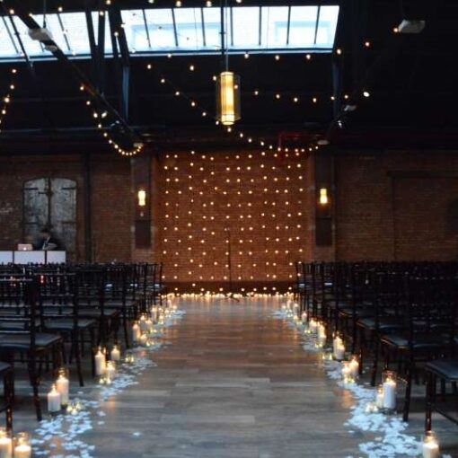 String Lights with round G50 bulbs hanging in a circular pattern in the main room at 26 Bridge.  Also, String Lights hanging vertically as a backdrop behind ceremony at 26 Bridge. 