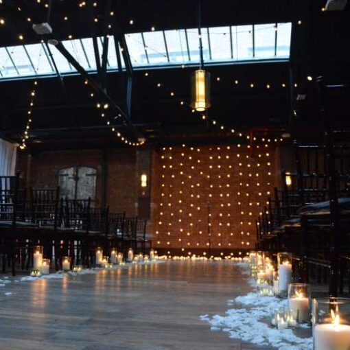 String Lights with round G50 bulbs hanging in a circular pattern in the main room at 26 Bridge.  Also, String Lights hanging vertically as a backdrop behind ceremony at 26 Bridge. 