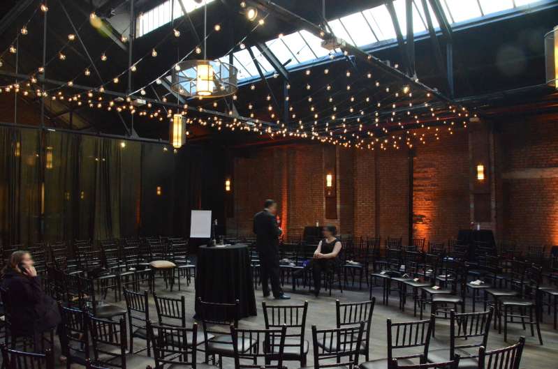 A canopy of string lights with round G50 bulbs hanging between 2nd and 3rd beam that cross the width of the main room at 26 Bridge.  Also, Amber Up-Lights around the perimeter of the main room.
