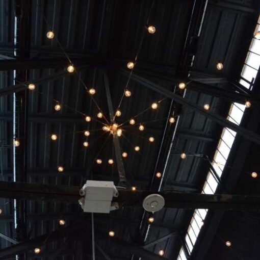String Lights with round G50 bulbs hanging in a circular/star shape above the main floor at 26 Bridge.