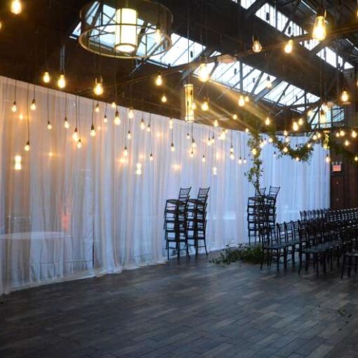 Pendant lamps with vintage antique Edison bulbs are hanging over the dance floor at 26 Bridge. Also, amber up-lights are along the perimeter wall of the main room.