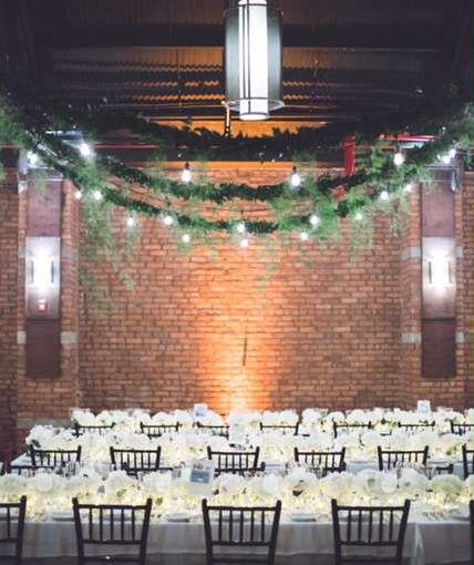 String Lights hanging in Parallel lines over the length of the main room for a wedding at 26 Bridge.
