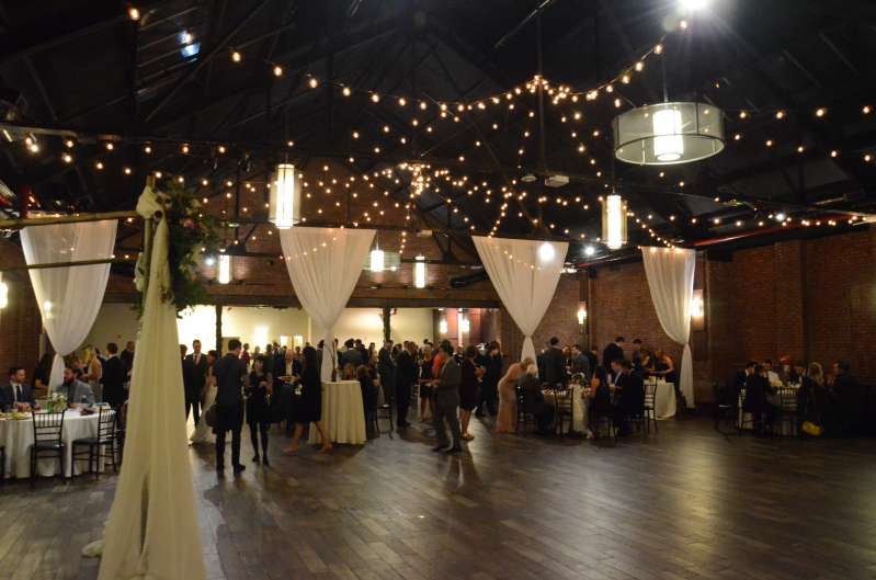String Lights hanging in a two Circular/Star star shaped patterns over the main room for a wedding at 26 Bridge.