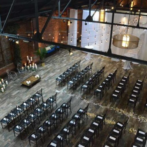 String Lights hanging in a circular pattern with round G50 bulbs for a wedding in the main room at 26 Bridge. Also, Up-Lights along the perimeter walls of the main room at 26 Bridge.