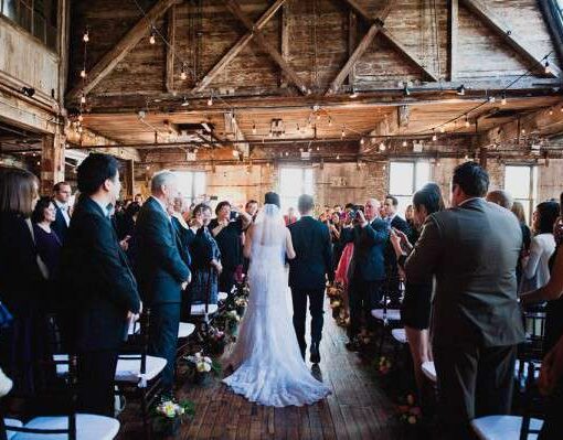 Warm White String Lights hanging in a zigzagging pattern between the six center columns for a wedding in the main room at The Greenpoint Loft.