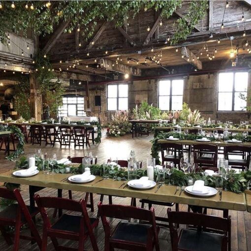 Warm White String Lights hanging in a zigzagging pattern between the six center columns for a wedding in the main room at The Greenpoint Loft.