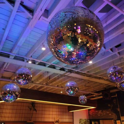 A cluster of decorative Mirror Balls (Disco Balls) hanging in the main restaurant for Brex's 2023 holiday party at Rule of Thirds.
