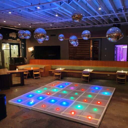 Mirror Balls (Disco Balls) hanging over an LED dance floor provided by Extreme Video Game Zone for Brex's Holiday Party at Rule of Thirds.