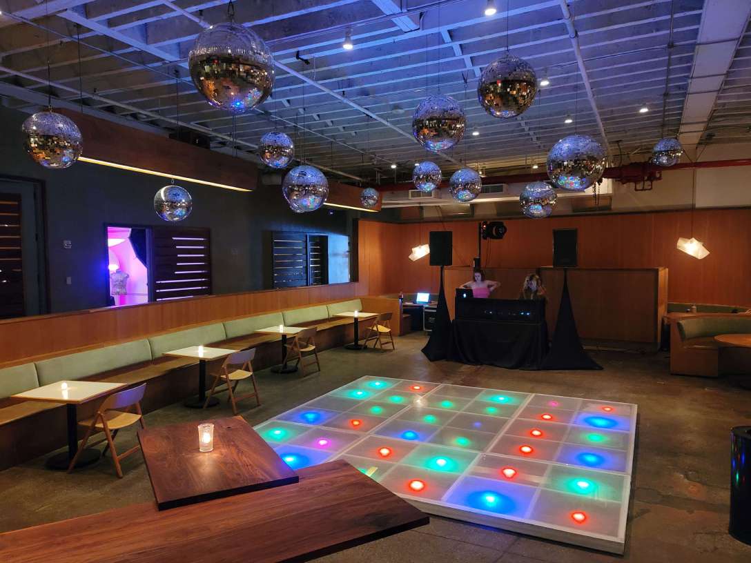 Mirror Balls (Disco Balls) hanging over an LED dance floor provided by Extreme Video Game Zone for Brex's Holiday Party at Rule of Thirds.