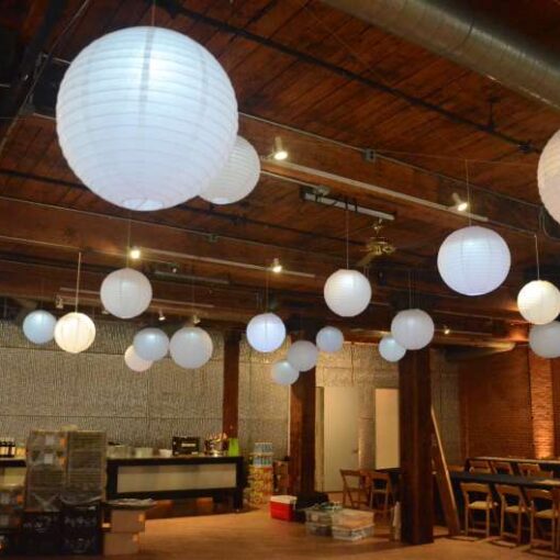 Paper Lanterns with decorative LED lights inside hanging between the center columns at The Dumbo Loft.