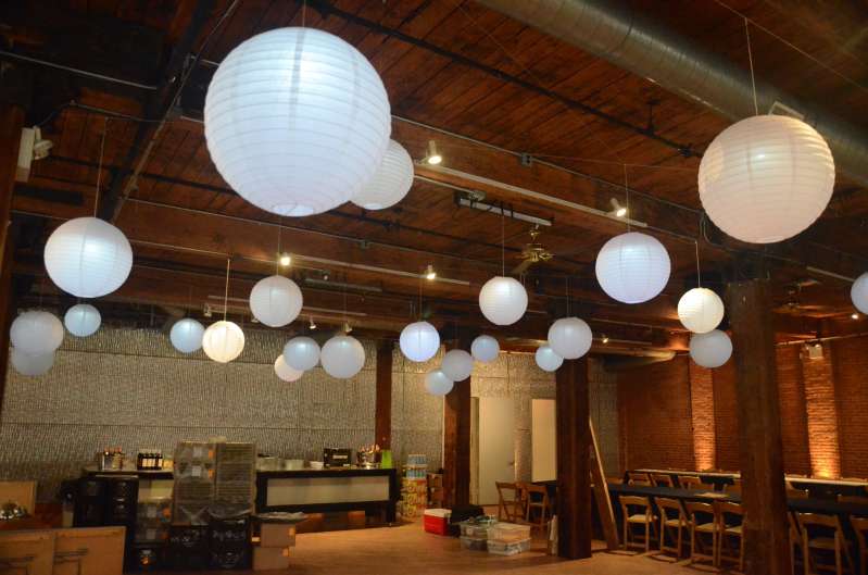 Paper Lanterns with decorative LED lights inside hanging between the center columns at The Dumbo Loft.