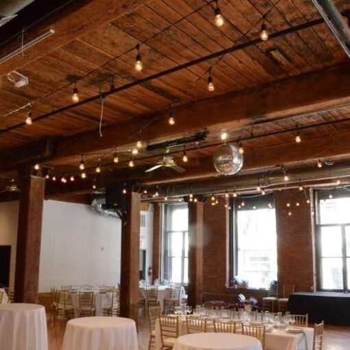 String Lights with S14 bulbs in a zigzagging pattern between the center columns for a wedding at The Dumbo Loft.