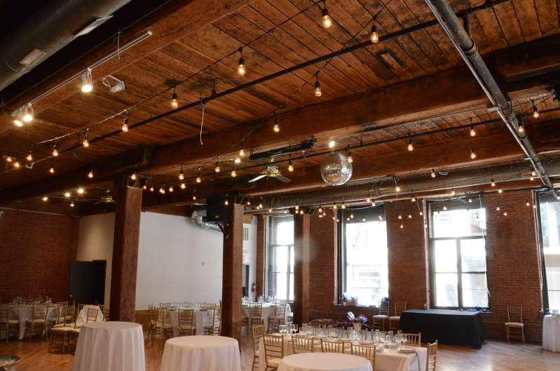 String Lights with S14 bulbs in a zigzagging pattern between the center columns for a wedding at The Dumbo Loft.