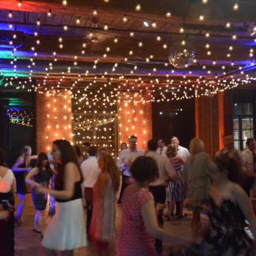 String Lights hanging vertically as a backdrop/curtain of lights behind ceremony. Also, a canopy of String Lights hanging between the center columns over the dance floor.