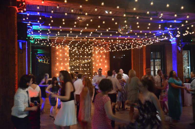 String Lights hanging vertically as a backdrop/curtain of lights behind ceremony. Also, a canopy of String Lights hanging between the center columns over the dance floor.