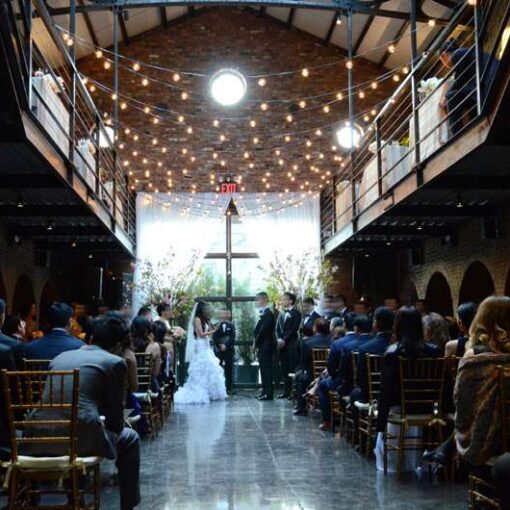 Warm white string lights hanging across the mezzanine level for a wedding in the main room at The Foundry.