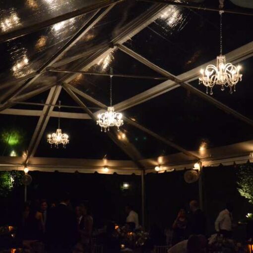 Crystal Chandeliers are hanging under a clear-top tent in the courtyard for a wedding at The Foundry.