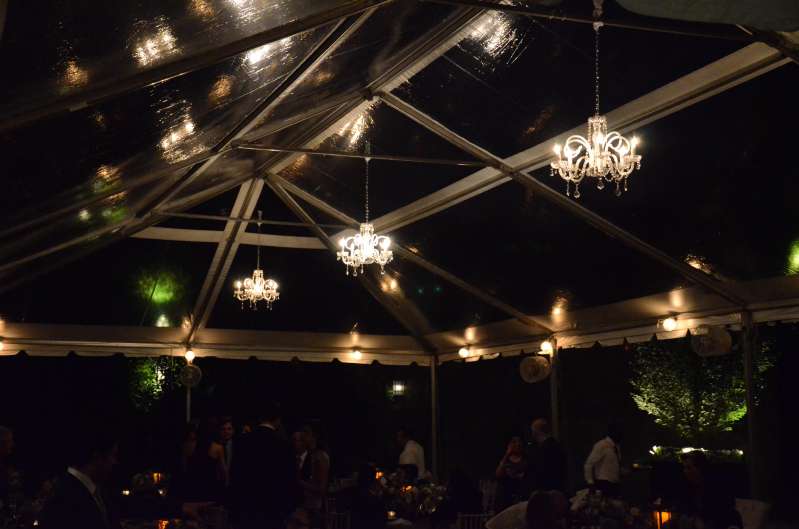 Crystal Chandeliers are hanging under a clear-top tent in the courtyard for a wedding at The Foundry.
