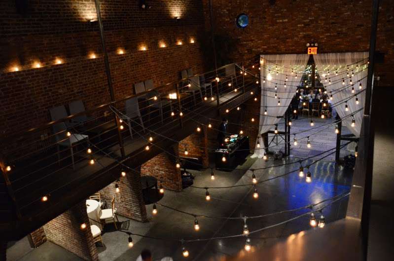 Warm white string lights hanging across the mezzanine level for a wedding in the main room at The Foundry.