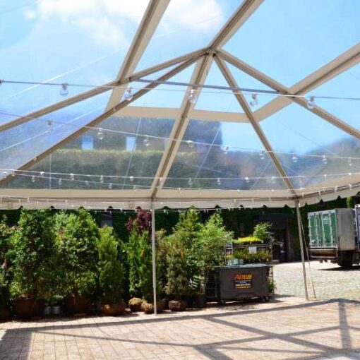 String Lights hanging outdoors under a clear-top tent for a wedding in The Courtyard at The Foundry.