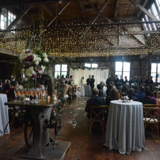 A canopy of Twinkle Lights hanging between the six center columns for a wedding in the main room at The Greenpoint Loft.