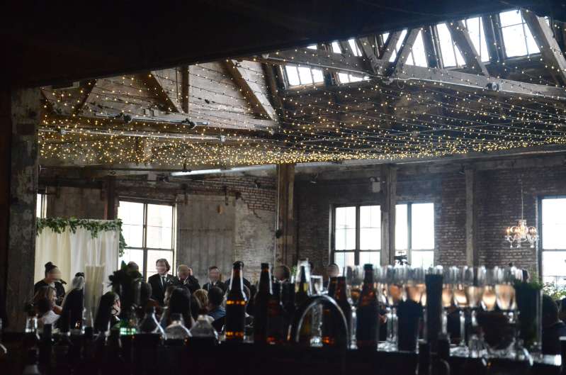 A canopy of Twinkle Lights hanging between the six center columns for a wedding in the main room at The Greenpoint Loft.