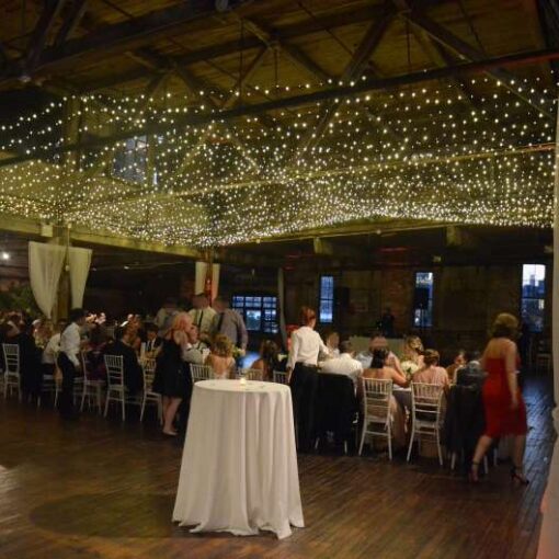A canopy of Twinkle Lights hanging between the six center columns for a wedding in the main room at The Greenpoint Loft.