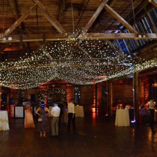 A canopy of Twinkle Lights hanging between the six center columns for a wedding in the main room at The Greenpoint Loft.