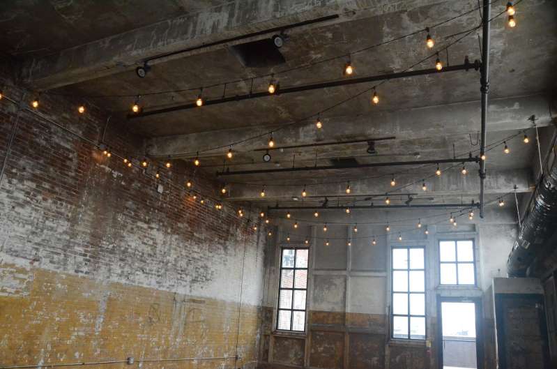 Warm White String Lights hanging in a zigzagging pattern on the mezzanine level for a wedding at The Greenpoint Loft.