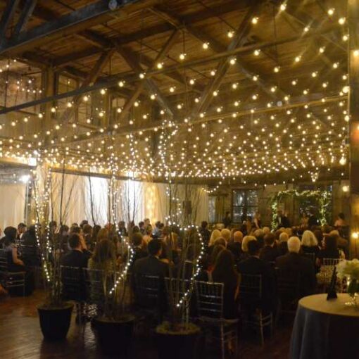 A canopy of warm white string lights hanging in the main room in a zigzagging pattern for a wedding at The Greenpoint Loft.
