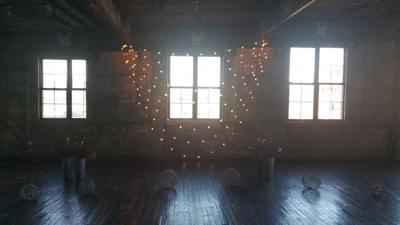 String Lights hanging against a wall with multiple swoops for a wedding at The Greenpoint Loft.