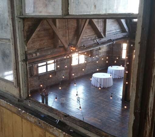 String Lights hanging overhead in a V-shaped pattern for a wedding at The Greenpoint Loft.