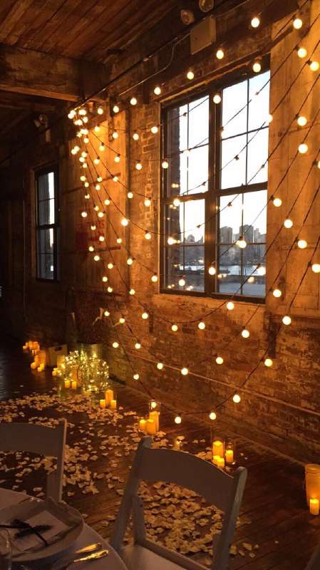 String Lights hanging against a wall with multiple swoops for a wedding at The Greenpoint Loft.