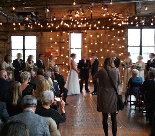 String Lights hanging against a wall in vertical lines for a wedding at The Greenpoint Loft.