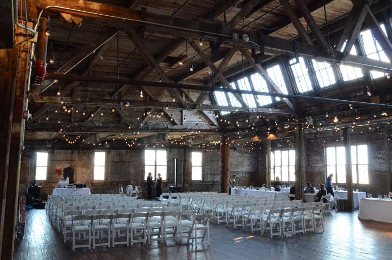 Warm White String Lights hanging in a zigzagging pattern between the six center columns for a wedding in the main room at The Greenpoint Loft.