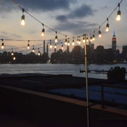 Warm White String Lights are hanging above the rooftop terrace for a wedding at The Greenpoint Loft.