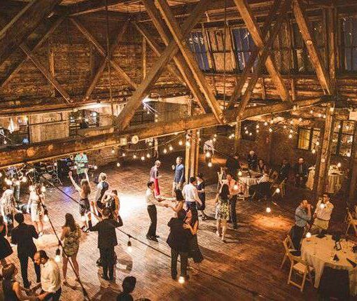 String Lights hanging in a zigzagging pattern between the six center columns for a wedding in the main room at The Greenpoint Loft.