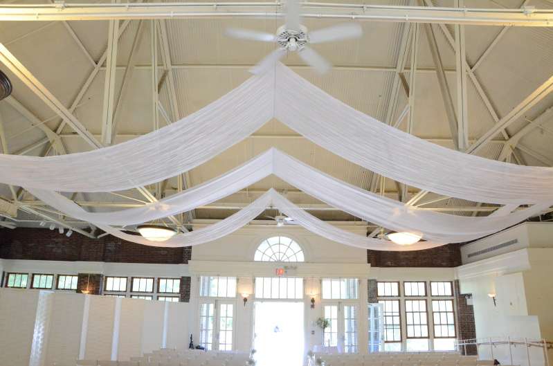 Three rows of white sheer fabric with multiple swoops hanging over the length of the main room at The Prospect Park Picnic House.