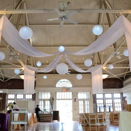 Paper Lanterns hanging with String Lights (Cafe Lights/ Bistro Lights) and white drapes at The Prospect Park Picnic House.