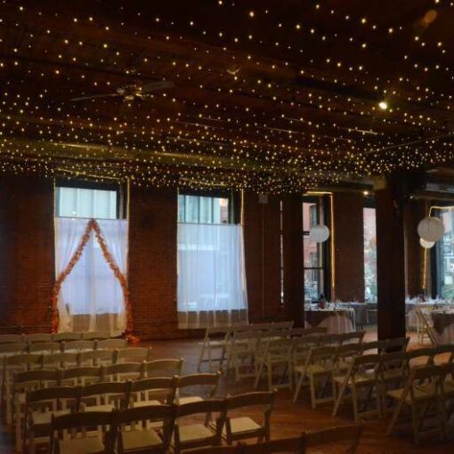 A Canopy of Twinkle Lights between the center columns at The Dumbo Loft.  Also, Paper Lanterns each with a decorative LED Light inside.