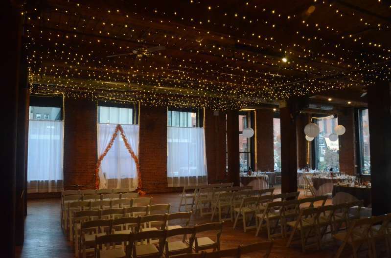 A Canopy of Twinkle Lights between the center columns at The Dumbo Loft.  Also, Paper Lanterns each with a decorative LED Light inside.