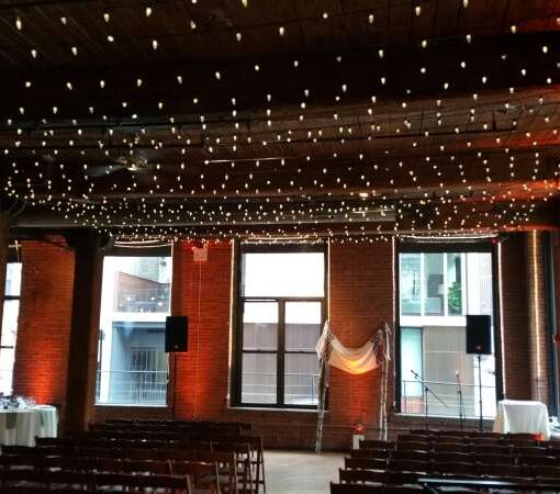 A canopy of C7 LED String Lights over the dance floor at The Dumbo Loft. Also Up-Lights around the perimeter of the room.