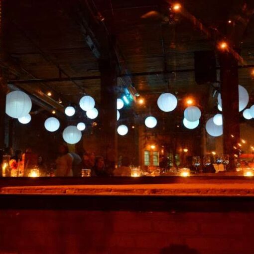 Paper Lanterns with decorative LED lights inside hanging over dance floor for wedding at the Dumbo Loft.