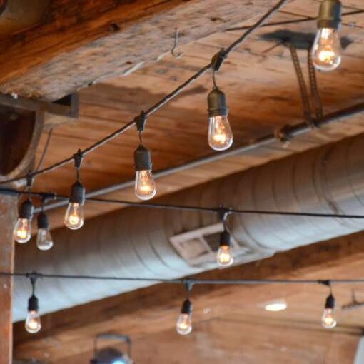 String Lights (Bistro Lights/ Cafe Lights) hanging between the center columns for a wedding at The Dumbo Loft.