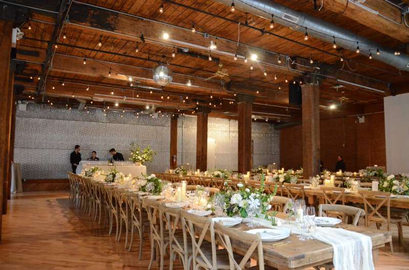 String Lights with S14 bulbs hanging in a zigzag pattern between the center columns for a wedding at The Dumbo Loft.