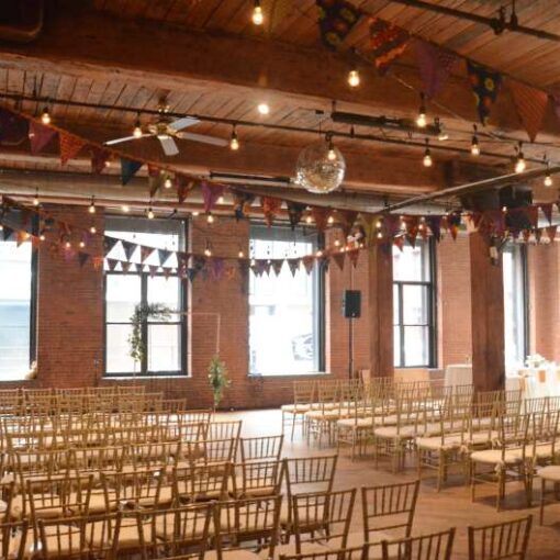 String Lights hanging between center columns for a wedding at The Dumbo Loft with pennant flags.